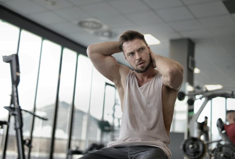 Confident sportsman resting after training in gym